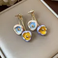 Macro view of handmade colorful enamel flower drop earrings on luxury jewelry pad - Style 22 (Silver Pin-Eco-Gold) / Pink Purple