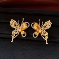 Close-up of gold butterfly earrings with yellow zircons on elegant black background. - Silver Needle Studs / Gold-Yellow