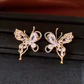 Close-up of 18K gold plated butterfly earrings with sparkling clear zirconia stones - Silver Needle Studs / Gold-White