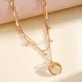 Close-up of stylish layered rose gold necklace featuring crescent moon and star pendants - Gold