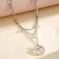Detail shot of a silver-colored layered necklace with star and crescent moon charms - Silver