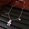 Macro view of silver bead necklace featuring pearl bear and pink heart zircon charms - Silver