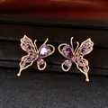 Macro view of detailed 18K gold plated butterfly stud earrings with purple zircons - Silver Needle Studs / Gold-Purple