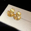 Macro detail of vintage amber crystal semi-circle earrings on a gray display pad - Vintage Semicircular Ear Clip (HE34030) / Gold/Brown