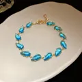 Detailed close-up of a sparkling blue teardrop zircon bracelet with gold-tone finish - Gold-Light Blue