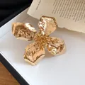 Close-up of elegant gold metal flower bracelet featuring unique wrinkled petal texture - Ring / Gold