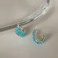 Dettaglio di orecchini a cerchio intrecciati con cristalli blu - Argento, Blu