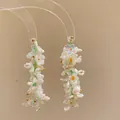 Detail of handmade beaded earrings with white flowers and pearls - White