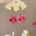 Close-up of sweet pink enamel flower dangle earrings on a ginkgo leaf card. - Silver Earring Post - Pink