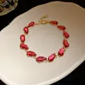 Detailed shot of a gold bracelet featuring red teardrop-shaped sparkling zirconia stones - Gold-Rose Red
