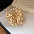 Detailed view of the wrinkled metallic flower texture on this elegant gold-toned cuff - Ring / Gold