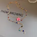 Detailed view of a vintage gold-tone necklace with colorful crystal beads and pink flower. - Gold