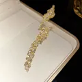 Detail view showing marquise-cut zircons on a gold-plated leaf-shaped open ring - Gold