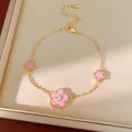 Detailansicht eines vergoldeten Armbands mit rosa Blumen und einem Zirkonia-Stein. - Armband / Gold / Rosa