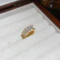Close-up of 18k gold plated ear cuff with four baguette-cut zirconia stones - Single Piece / Gold with White Zirconia