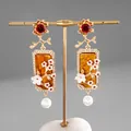 Boucles d'oreilles vintage élégantes en résine avec fleurs et perles blanches fines. - Or & Marron
