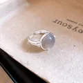 Macro view of minimalist silver open ring with a smooth grey oval cabochon stone. - Oval Blue Stone Style / Silver