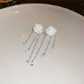 Close-up of elegant white acrylic rose tassel earrings with shimmering crystals. - Silver Earring Post Style / Silver-White