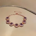 Elegante bracciale in oro rosa con grappoli di zirconi viola su superficie riflettente. - Bracciale Stile Fiore / Oro rosa - Viola