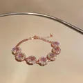 Primo piano di un bracciale in oro rosa con fiori di zircone rosa su uno specchio - Bracciale Stile Fiore / Oro Rosa-Rosa