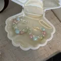 Detailed view of French style hoop earrings with pastel pearls and cubic zirconia stones - Pink Blue Green