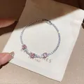 Gros plan d'un bracelet en zircone étincelant avec pierres roses sur pochette - Strass Carré Rose (2#) / Argent-Rose (2#)