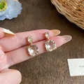 Close-up detail view of elegant 18k gold plated zircon earrings with clear stones. - Silver Earring Post - Gold (Real Gold Plated)