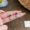 Macro view of elegant 18k gold plated zircon stud earrings with transparent sphere charms - Silver (Silver Pin)