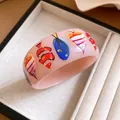 Detailed macro view of a stylish pink resin bangle with colorful tropical fish prints - Tropical Fish Print (HB6123) / Pink
