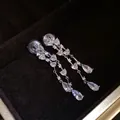 Vista dettagliata di orecchini lunghi a nappa con cristalli a cuore e pera - Orecchini a clip / Argento