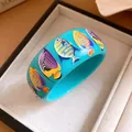 Close-up of wide blue resin bangle featuring vibrant tropical fish patterns in glossy finish. - Tropical Fish Print (HB6123) / Blue