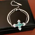 Elegant double-layered jewelry featuring a green zircon cross pendant and white pearls - Bracelet / Silver-Green