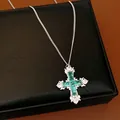 Close-up of elegant cross necklace with green and clear cubic zirconia stones - Necklace / Silver-Green