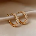 Gros plan d'élégantes créoles dorées creuses en forme de C serties de zircons brillants - Boucles d'oreilles en C creux doré avec tige en argent 925 et strass (71#) / Or