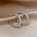Gros plan de boucles d'oreilles créoles zigzag en argent avec pierres zircons - Boucles d'oreilles en C ajourées ondulées (72#) / Argent