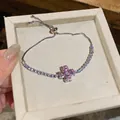 Elegant silver adjustable bracelet with pink zircon flower pendant on a beige tray - Bracelet / Pink