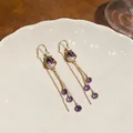 Detail view of 18k gold plated tulip earrings with purple zircon and tassel chains - Silver Earring Post Style / Gold + Purple