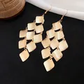 Detailed view of vintage matte gold tiered diamond-shaped tassel dangle earrings - Gold
