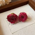 Detailed macro view of handmade real rosebud stud earrings with sterling silver pins - Rose Red