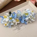 Close-up of elegant blue and white fabric flower hair clips on a textured tray - Duckbill Hair Clips / Single Piece / Blue