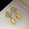 Detaillierte Nahaufnahme von 18k vergoldeten Blumenohrringen mit leuchtend gelben Edelsteinen - Gold