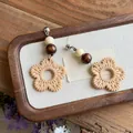 Handmade bohemian rattan woven floral earrings with wooden beads on a rustic wooden tray - Silver Earring Post Style / Brown