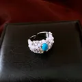 Detailed close-up of a vintage silver adjustable ring with white pearls and a blue oval stone - Silver