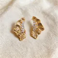 Macro view of 18k gold plated ruffled earrings featuring elegant zircon stone details - Pleated Geometric Style (HE32548) / Gold