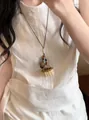 Détail d'un collier ethnique tissé à la main avec pendentifs mini panier et gland - Pendentif Panier en Pomme de Pin Tissé (HN12612) / Café/Blanc