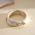 Detail of vintage resin bangle with marble effect and sparkling rhinestone accents. - Beige