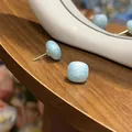 Detailed macro view of elegant blue enamel square stud earrings on a natural wood surface - Square Stud Earrings (HE33697-) / Blue