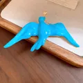 Detail of a vibrant blue enamel swallow brooch with a delicate gold star accent - Blue