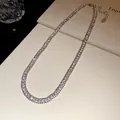 Detailed view of elegant double-row square-cut rhinestone tennis necklace on cream surface - Necklace / Silver