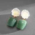 Primer plano detallado de pendientes cuadrados de resina con textura verde y blanca. - Verde & Transparente